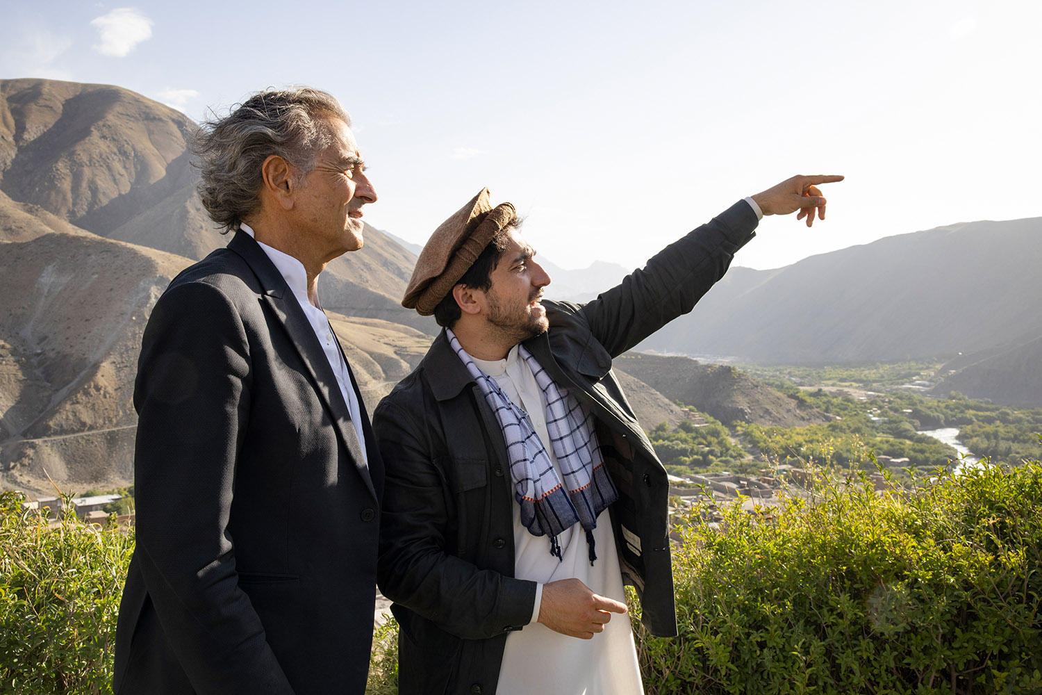 Bernard-Henri Lévy et Ahmad Massoud, au milieu des montagnes, Ahmad Massoud désigne quelque chose avec son doigt à Bernard-Henri Lévy.