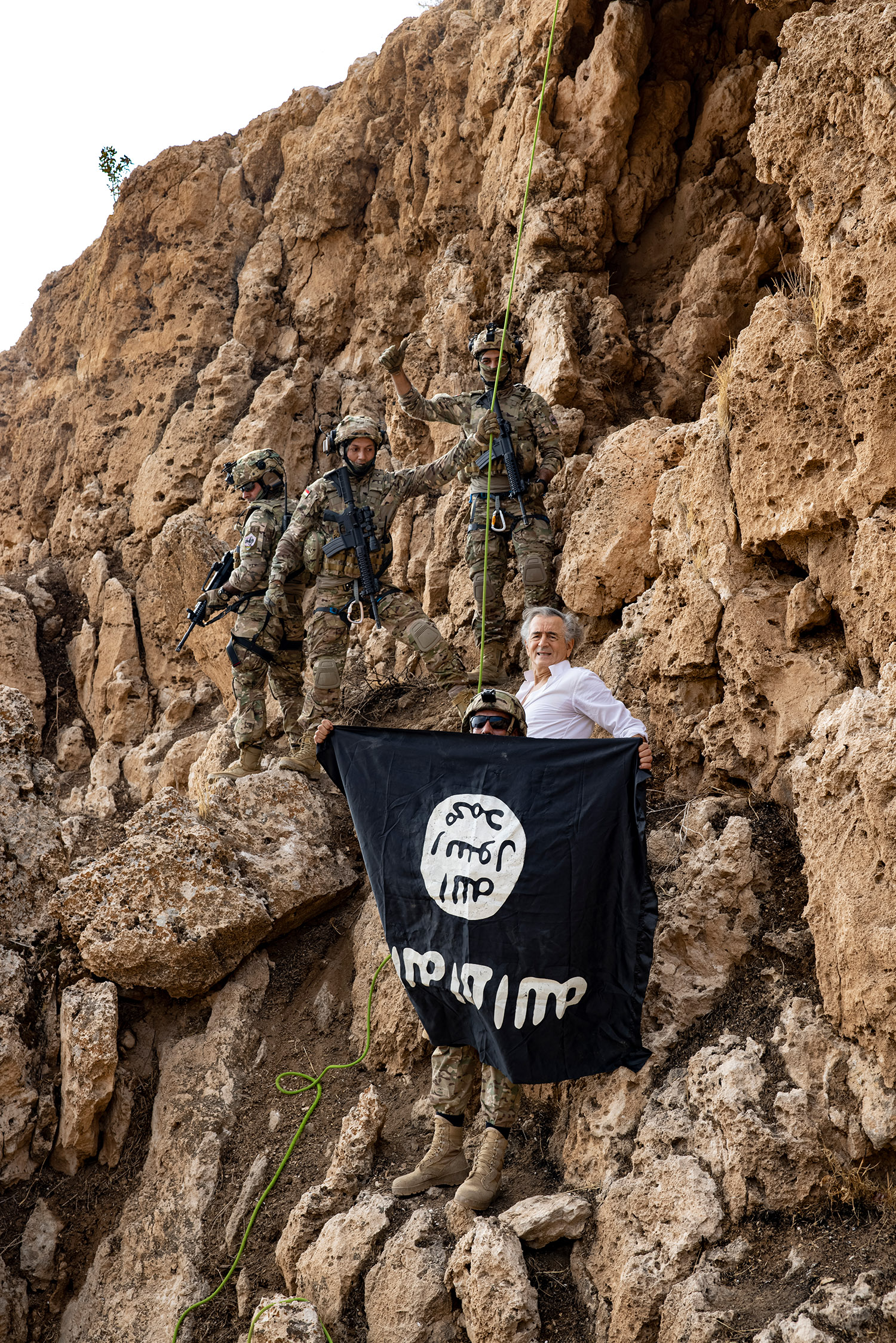 Sur le flanc d'une montagnes, avec des Peshmergas, à proximité des grottes de Daech, leurs symboles sont détruits.