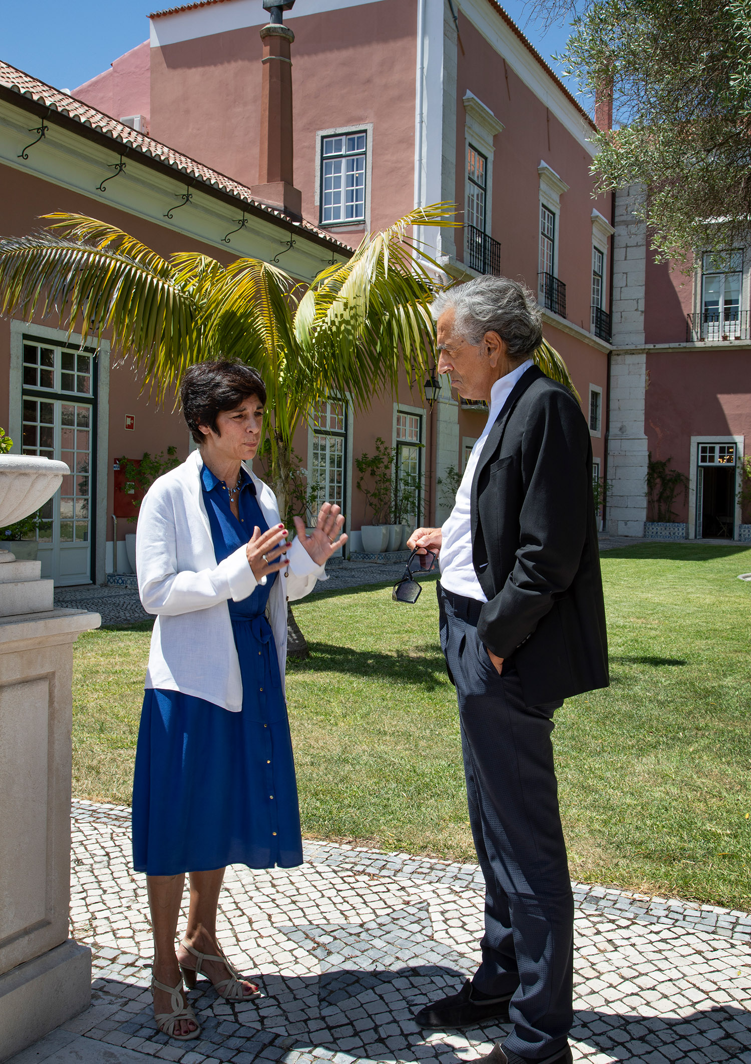 Dans les jardins du Palais de Santos, l’ambassade de France au Portugal, Bernard-Henri Lévy rencontre la Consule, Florence Mangin.