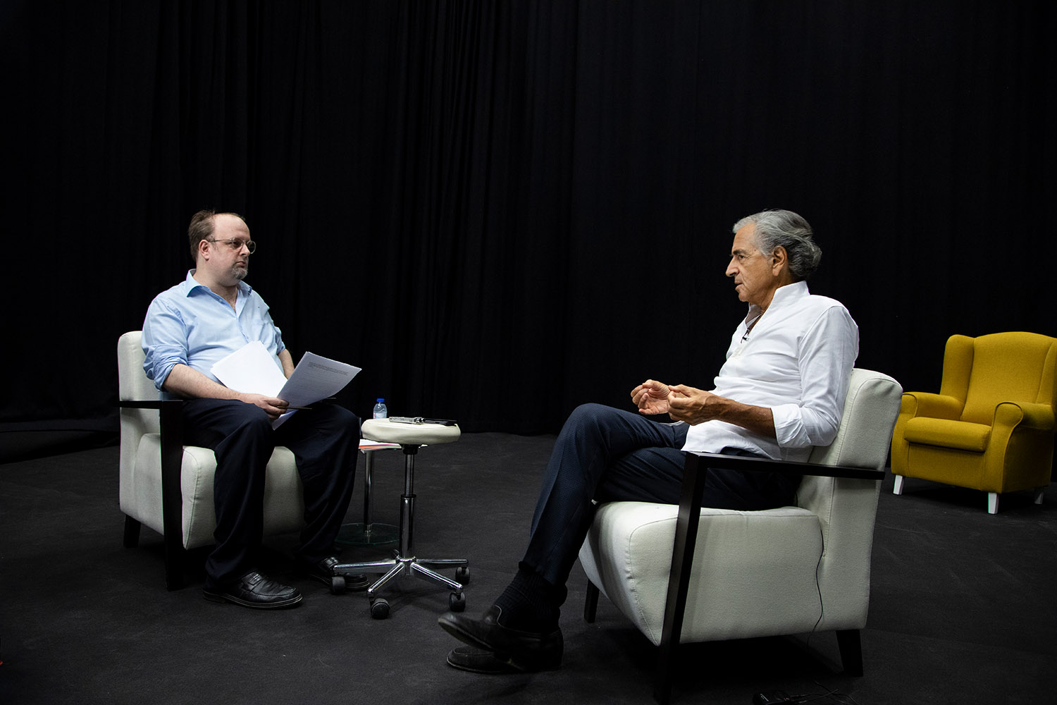 Pedro Mexia et Bernard-Henri Lévy réalisent un entretien, ils sont l'un et l'autre assis dans un fauteuil et se font face.