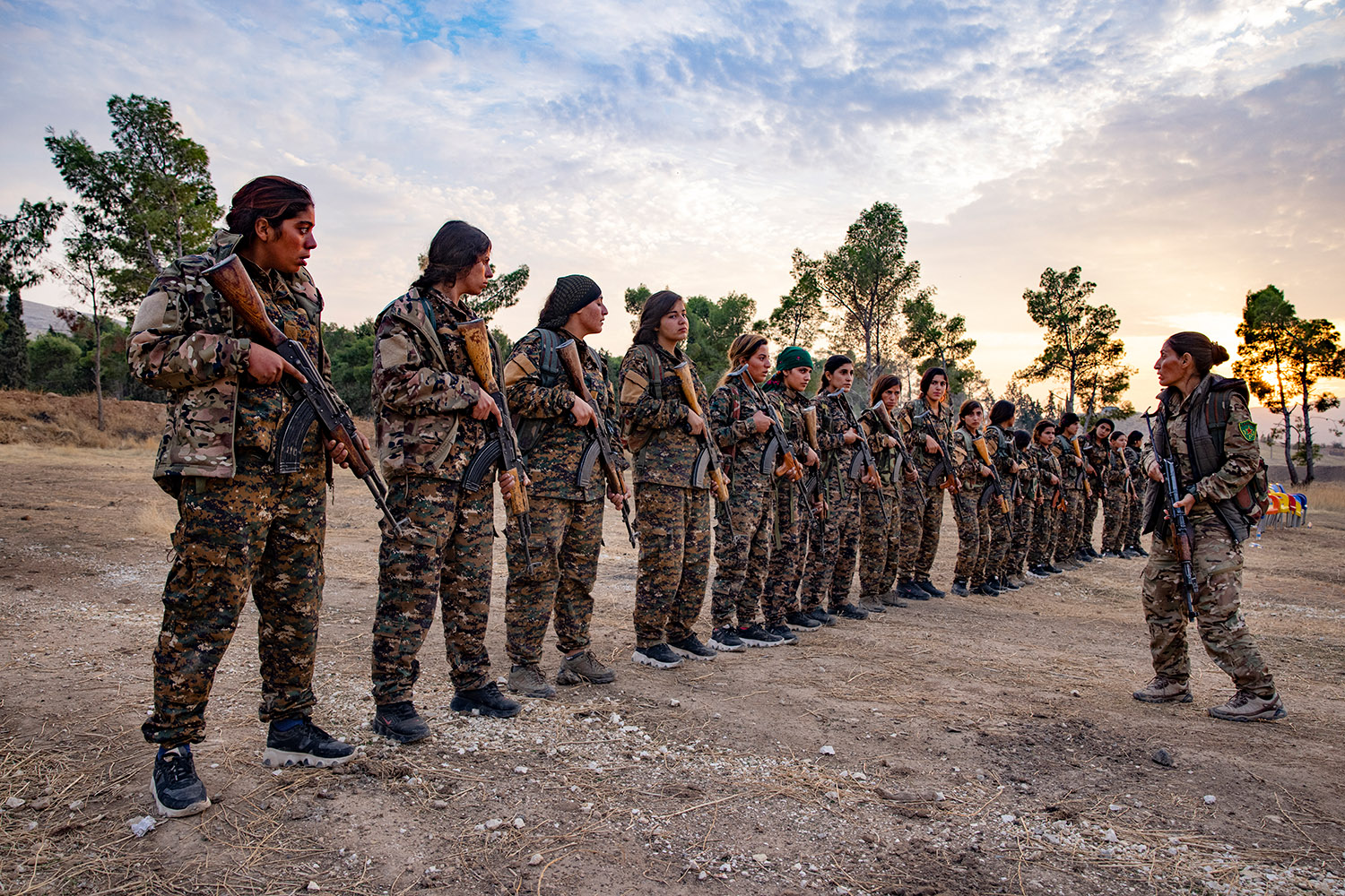 Des femmes en tenue de soldats, alignées, écoutent leur chef devant elles
