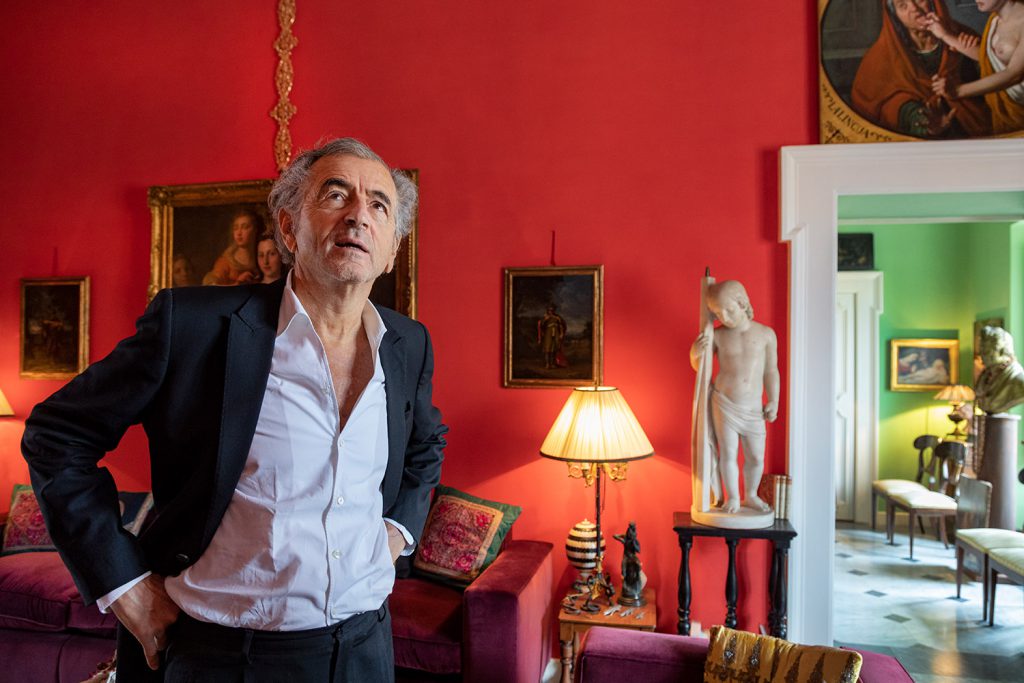 Bernard-Henri Lévy à Rome, dans un appartement repli d'oeuvres d'arts, de tableaux, de sculptures, sur des murs rouges et verts.