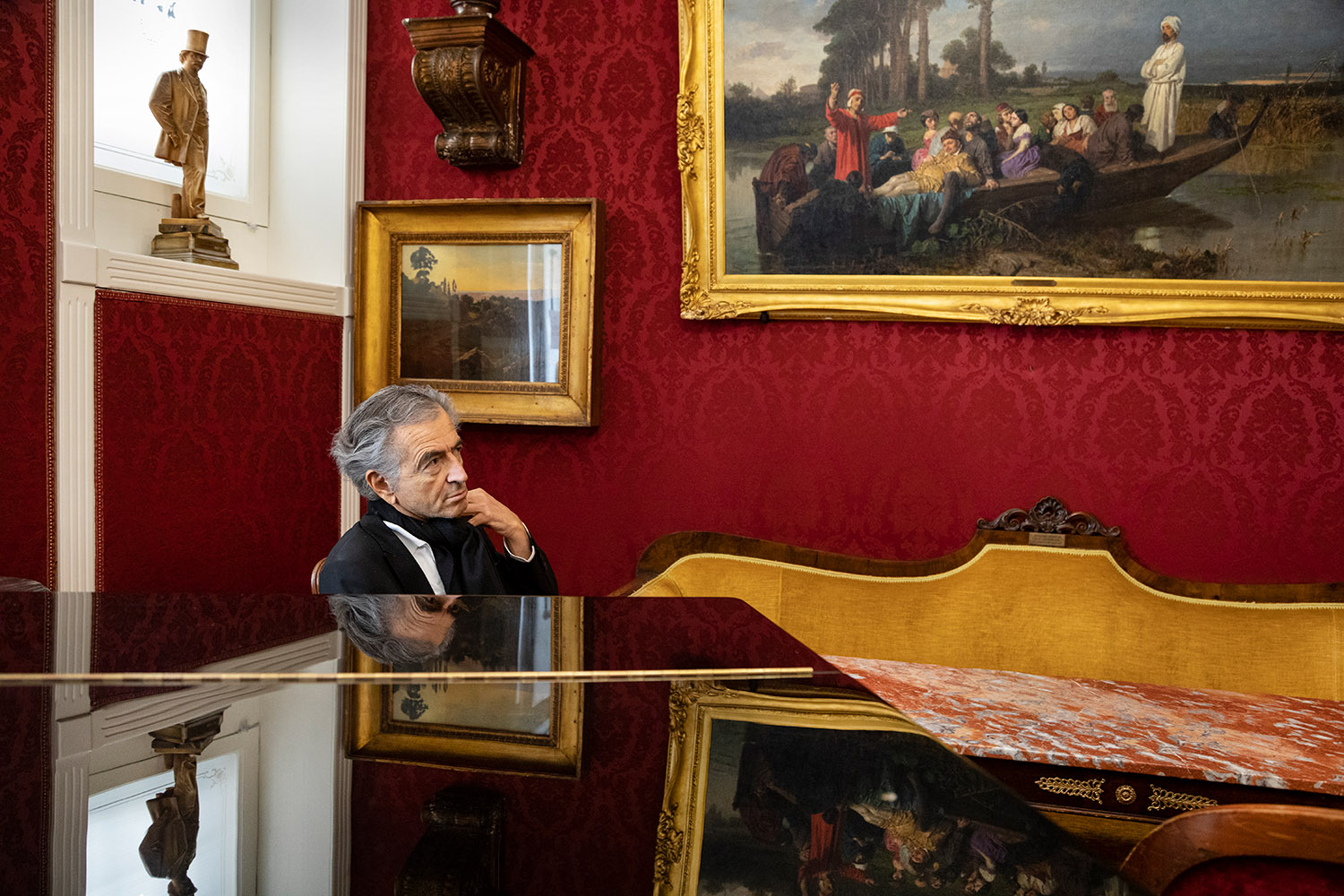 Bernard-Henri Lévy au café Greco de Rome. Le café est richement décoré par des tableaux.