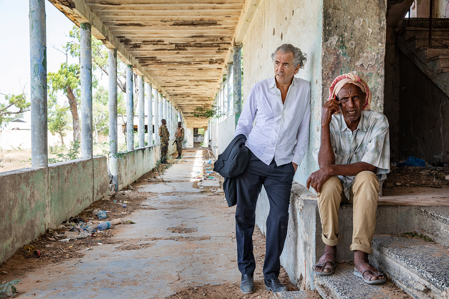 Bernard-Henri Lévy dans les ruines du Xooga Hospital, il parle avec un somalien.