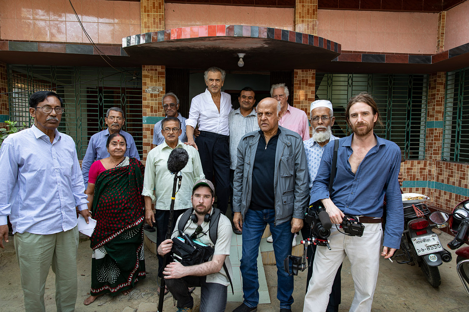En mars 2020 à Jessore au Bangladesh, Bernard-Henri Lévy, Gilles Hertzog, le directeur de la photographie Olivier Jacquin et l'ingénieur du son Nicolas Velasco, sont entourés par Akim Mukherjee et ses proches.