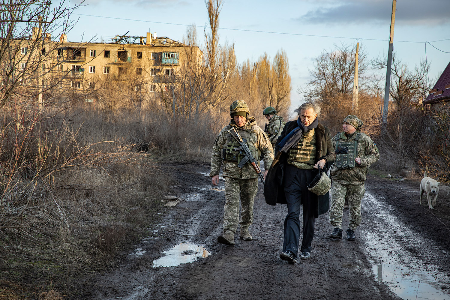 Bernard-Henri Lévy accompagné par des militaires ukrainiens dans les ruines de la ville de Pisky en Ukraine au mois de janvier 2020.