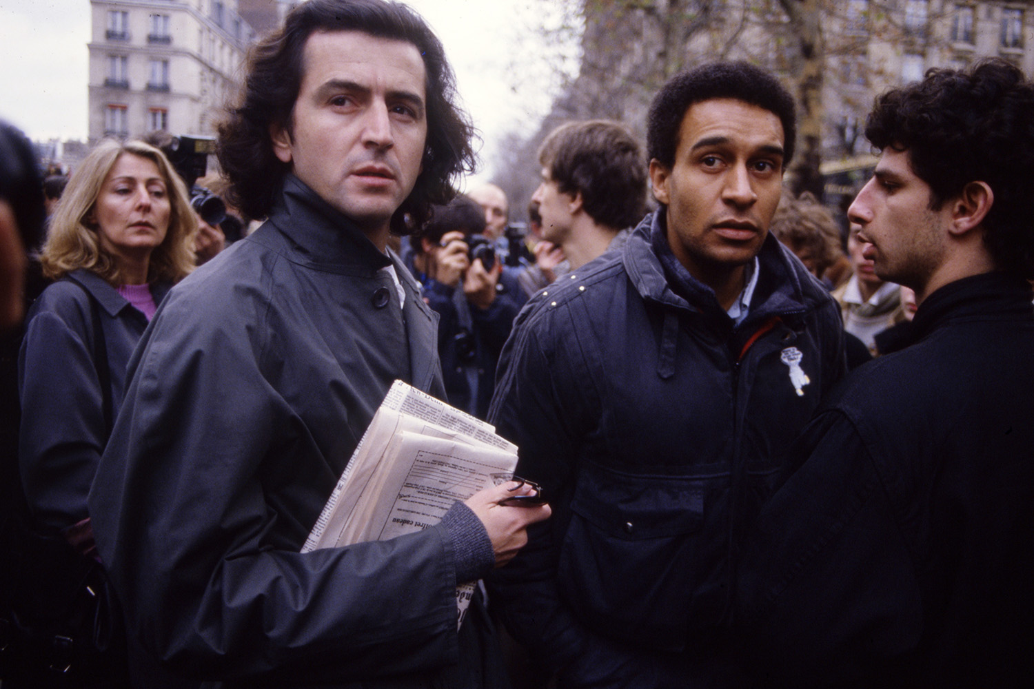 Photo en couleur de BHL avec Harlem Désir lors d'une manifestation de l'association SOS Racisme à Paris le 6 décembre 1986.
