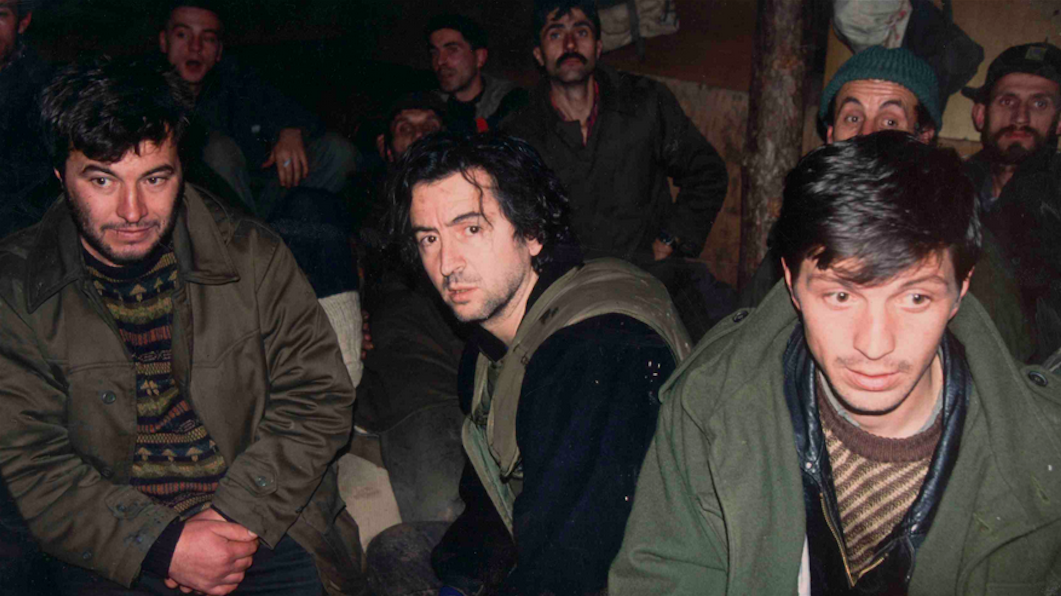 Photo en couleur de Bernard-Henri Lévy entouré de soldats bosniaques dans un bunker à Sarajevo en décembre 1993.