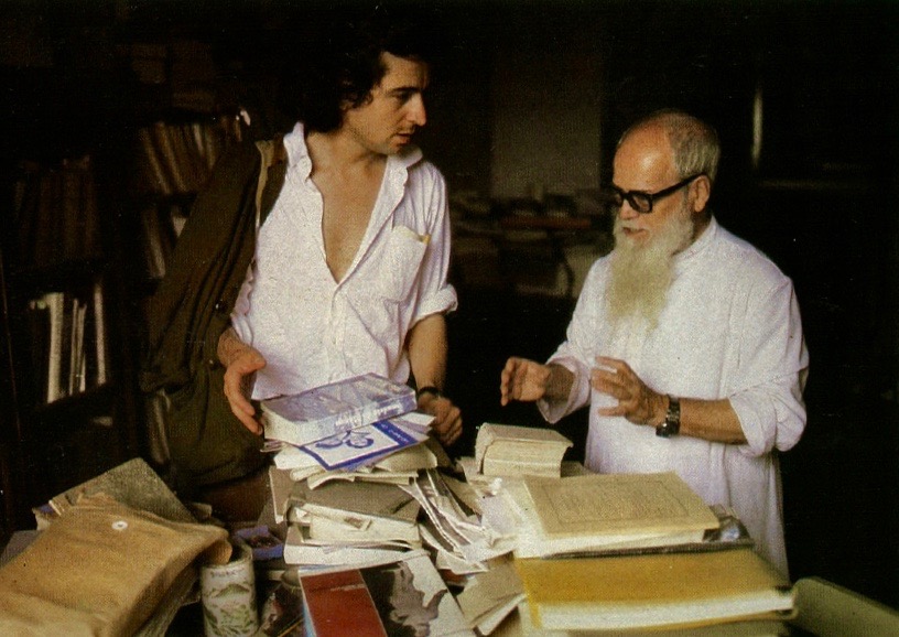 Photo en couleur de Bernard-Henri Lévy avec le prêtre Manual Tixieira dans une bibliothèque à Macao en 1985.