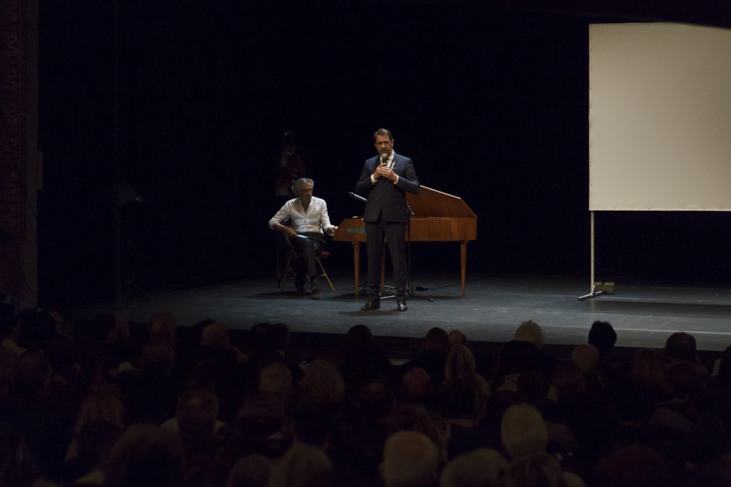 Christophe Castaner s'adresse au public du Théâtre Antoine lors meeting de solidarité avec le peuple ukrainien organisé par « La Règle du Jeu » le 1er mars 2022. Derrière lui, Bernard-Henri Lévy.