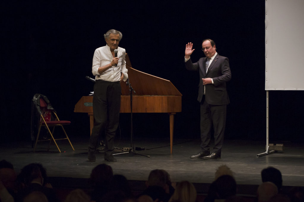 Bernard-Henri Lévy remercie François Hollande sur la scène du Théâtre Antoine lors meeting de solidarité avec le peuple ukrainien organisé par « La Règle du Jeu » le 1er mars 2022. Derrière eux, un clavecin.