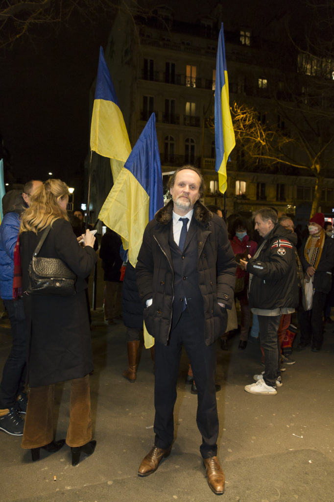 Jean-Marc Dumontet devant le Théâtre Antoine à l'issue du meeting de solidarité avec le peuple ukrainien organisé par « La Règle du Jeu » le 1er mars 2022. Derrière les le public porte des drapeaux de l'Ukraine.