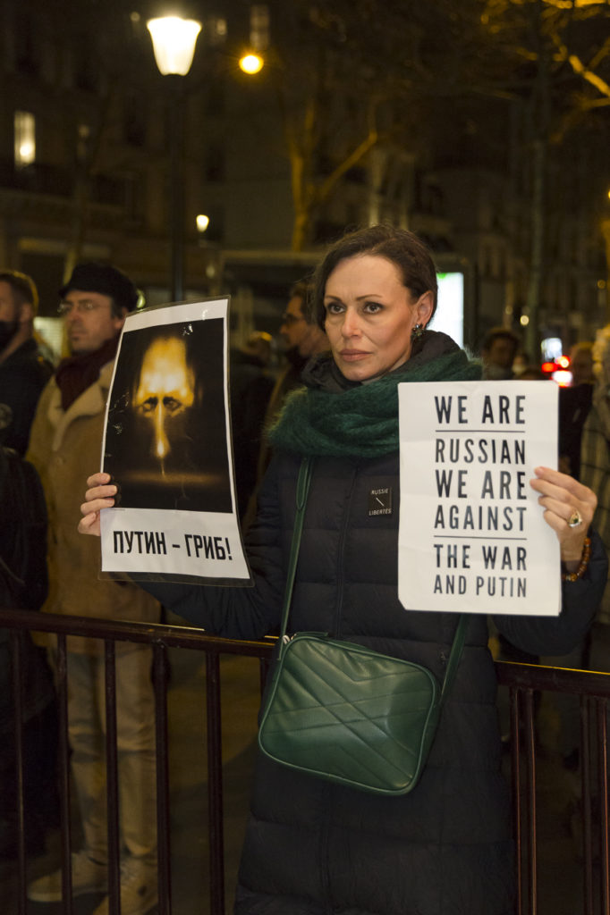 Devant le Théâtre Antoine à l'issue du meeting de solidarité avec le peuple ukrainien organisé par « La Règle du Jeu » le 1er mars 2022, une femme brandit des pancartes qui condamnent l'action de Poutine.