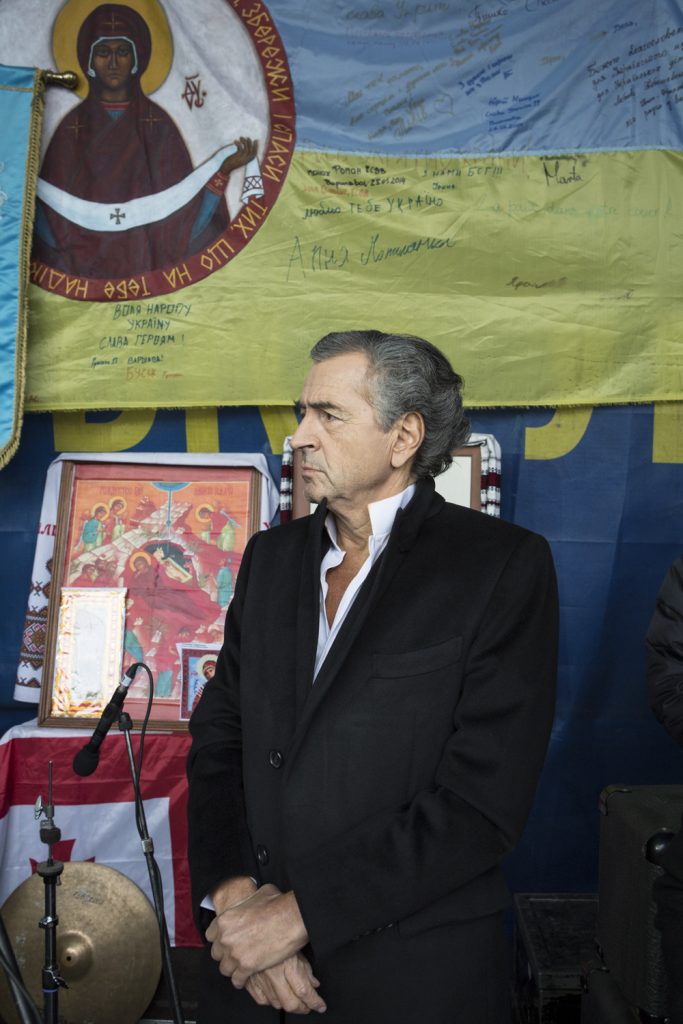 Bernard-Henri Levy sur la tribune de la place Maidan à Kiev le 2 mars 2014. Au fond des drapeaux de l'Ukraine et des icones religieuses.