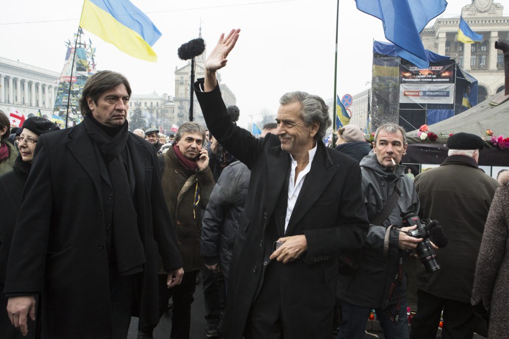 Bernard-Henri Levy saluant la foule qui porte des drapeaux ukrainiens sur la place Maidan, Kiev le 2 mars 2014.