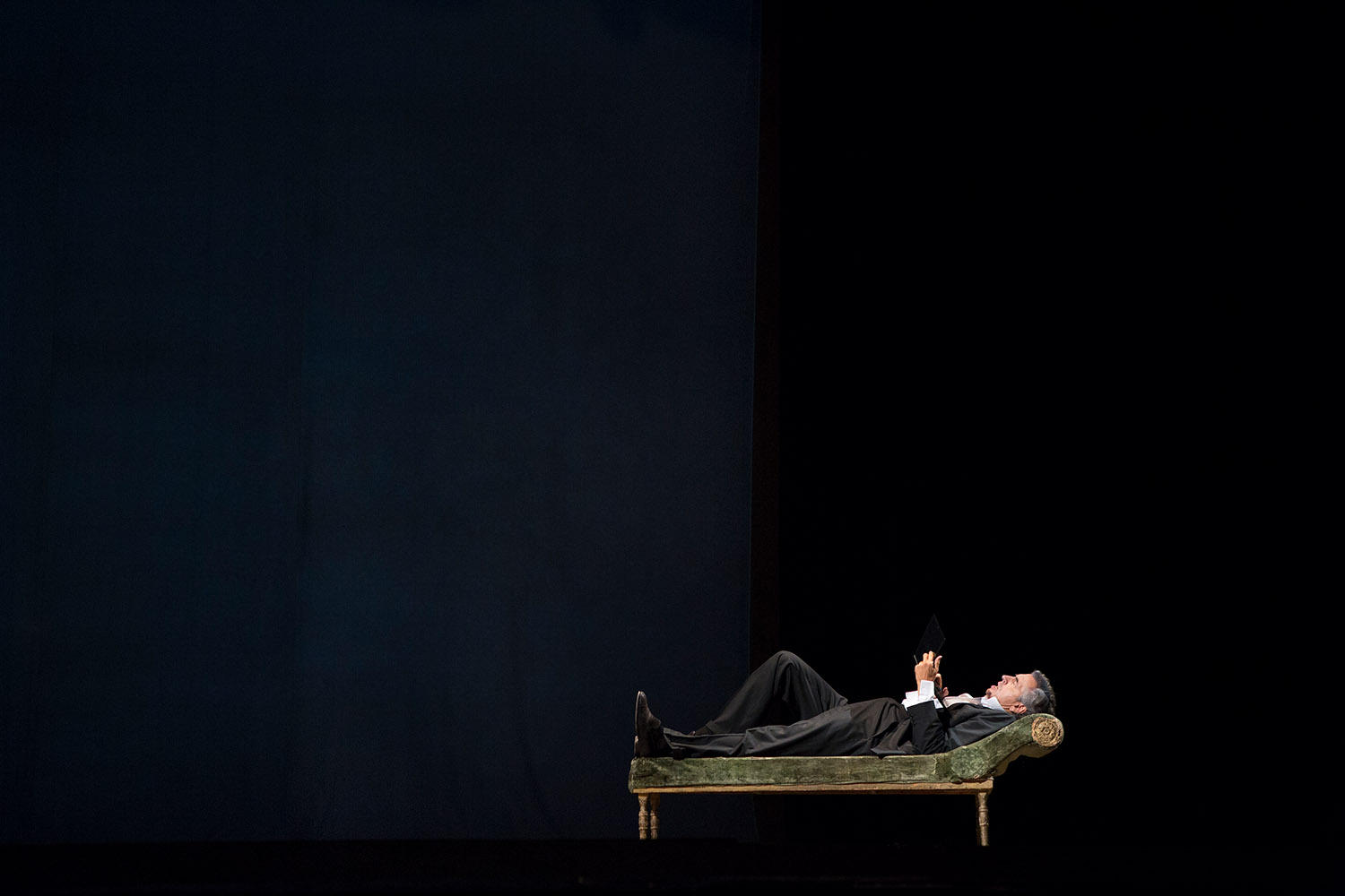 Bernard-Henri Lévy interprète sa pièce « Hôtel Europe » à l'Opéra d'Odessa. Il est allongé sur un divan et lit sur son ordinateur.