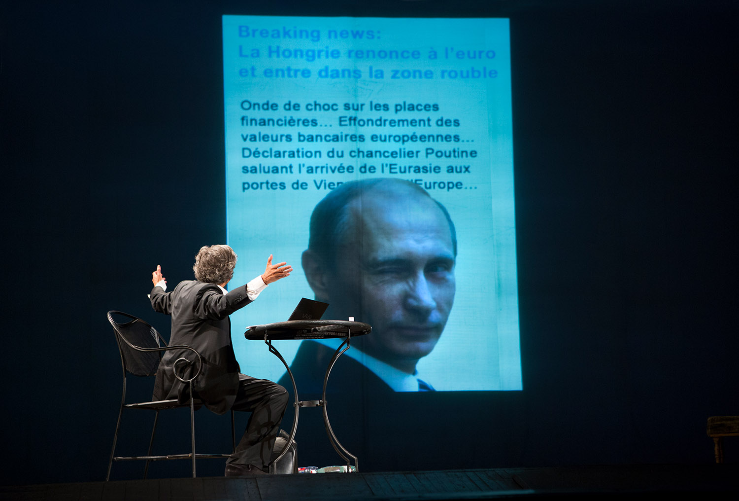 Bernard-Henri Lévy évoque Poutine, la Hongrie et l'Europe, dans l'interprétation qu'il fait de sa pièce « Hôtel Europe » à l'Opéra d'Odessa. Assis devant son ordinateur, BHL regarde le fond de la scène où est projeté le visage de Poutine faisant un clin d'oeil pour illustrer un article sur l'Europe, Poutine et la Hongrie.