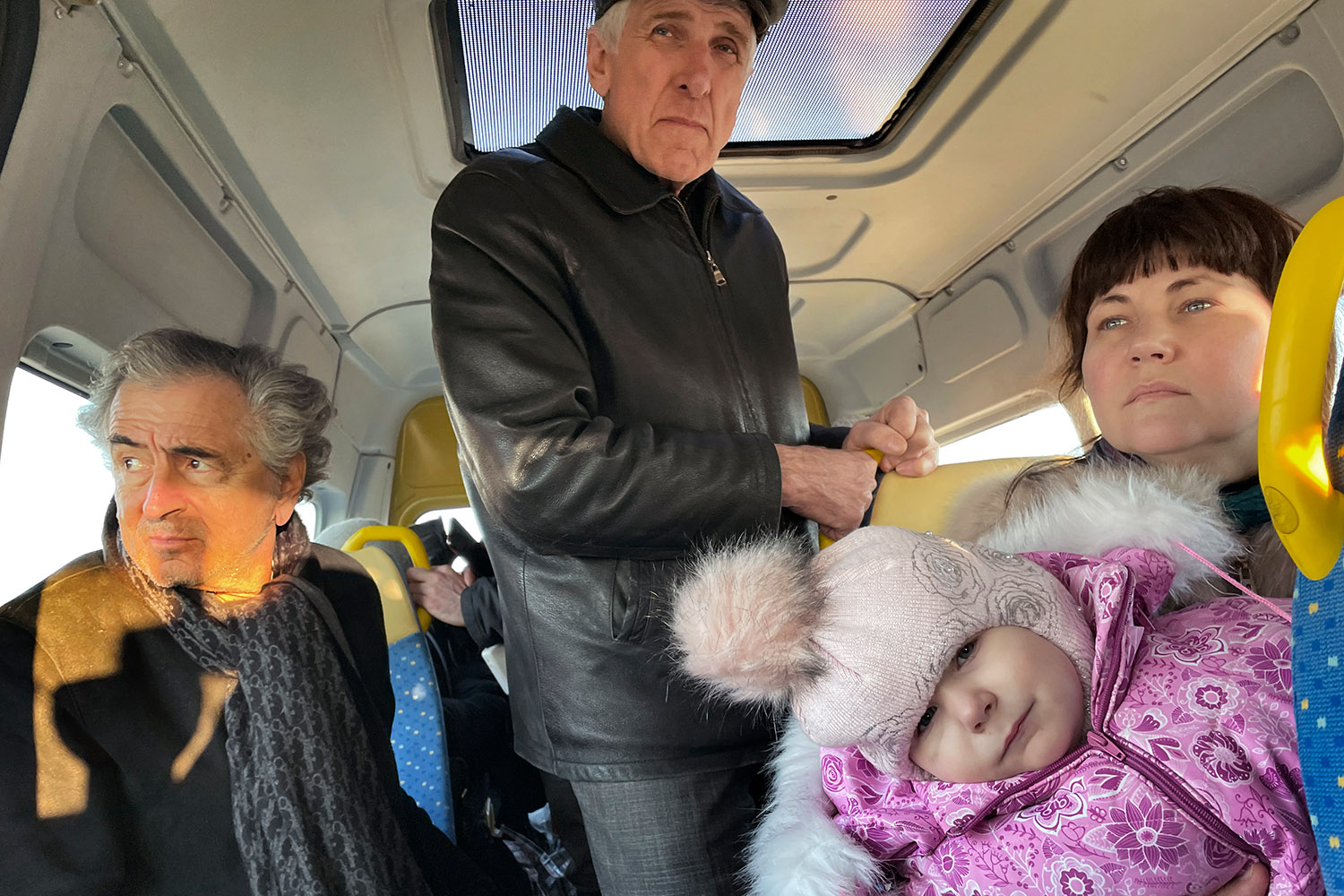 Bernard-Henri Lévy dans la navette qui conduit en Moldavie, entouré d'une famille avec un bébé.