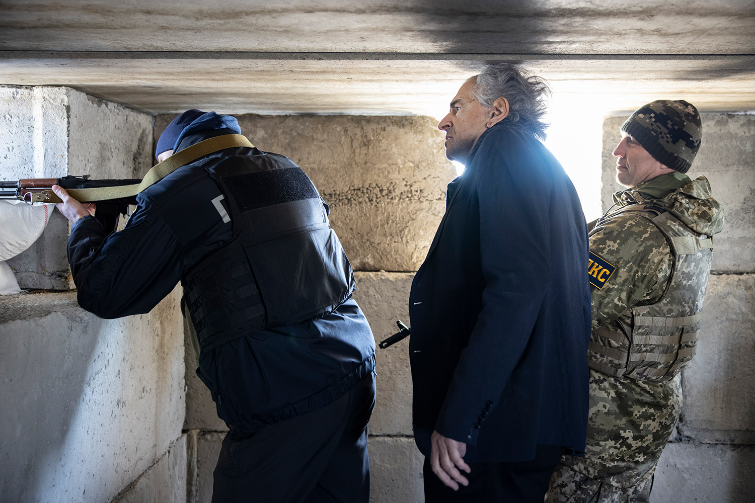 BHL avec un officier de la Défense territoriale, dans une des nombreuses casemates édifiées sur la route de Mykolaïv, à 30 kilomètres à l’est d’Odessa. Les militaires portent une arme.