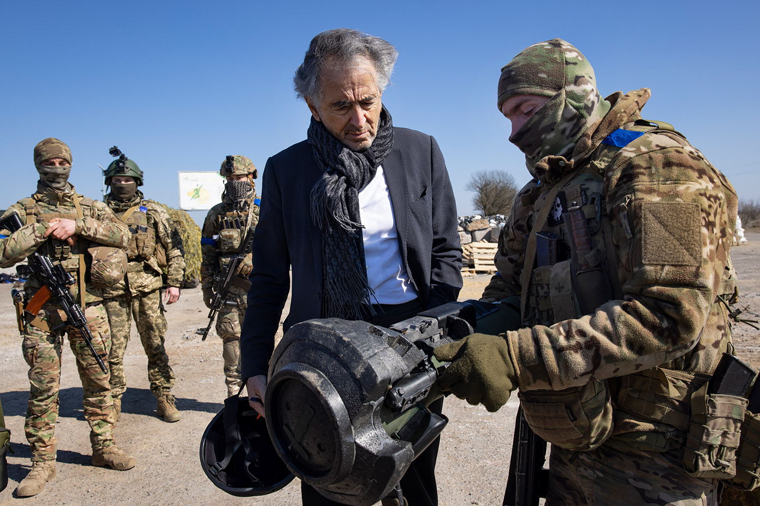 BHL avec un soldat en tenue militaire qui lui montre le fonctionnement d'un NLAW, arme antichars.