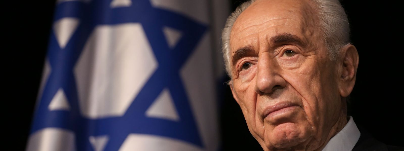 Portrait de Shimon Peres, à l'arrière plan on voit le drapeau d'Israël