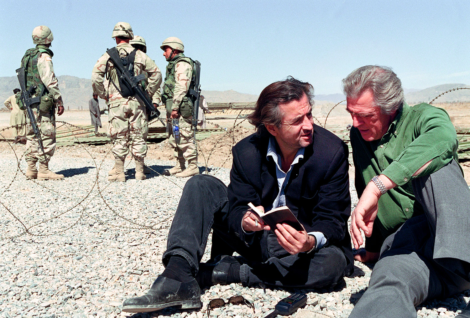 A l'aéroport de Kandahar Bernard-Henri Lévy etGilles Hertzog sont assis par terre, il y a derrière eux les forces spéciales américaines.