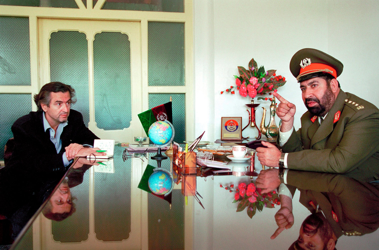 Bernard-Henri Lévy parle avec Gul Agha Sherzai qui porte un uniforme militaire dans un bureau à Kandahar.