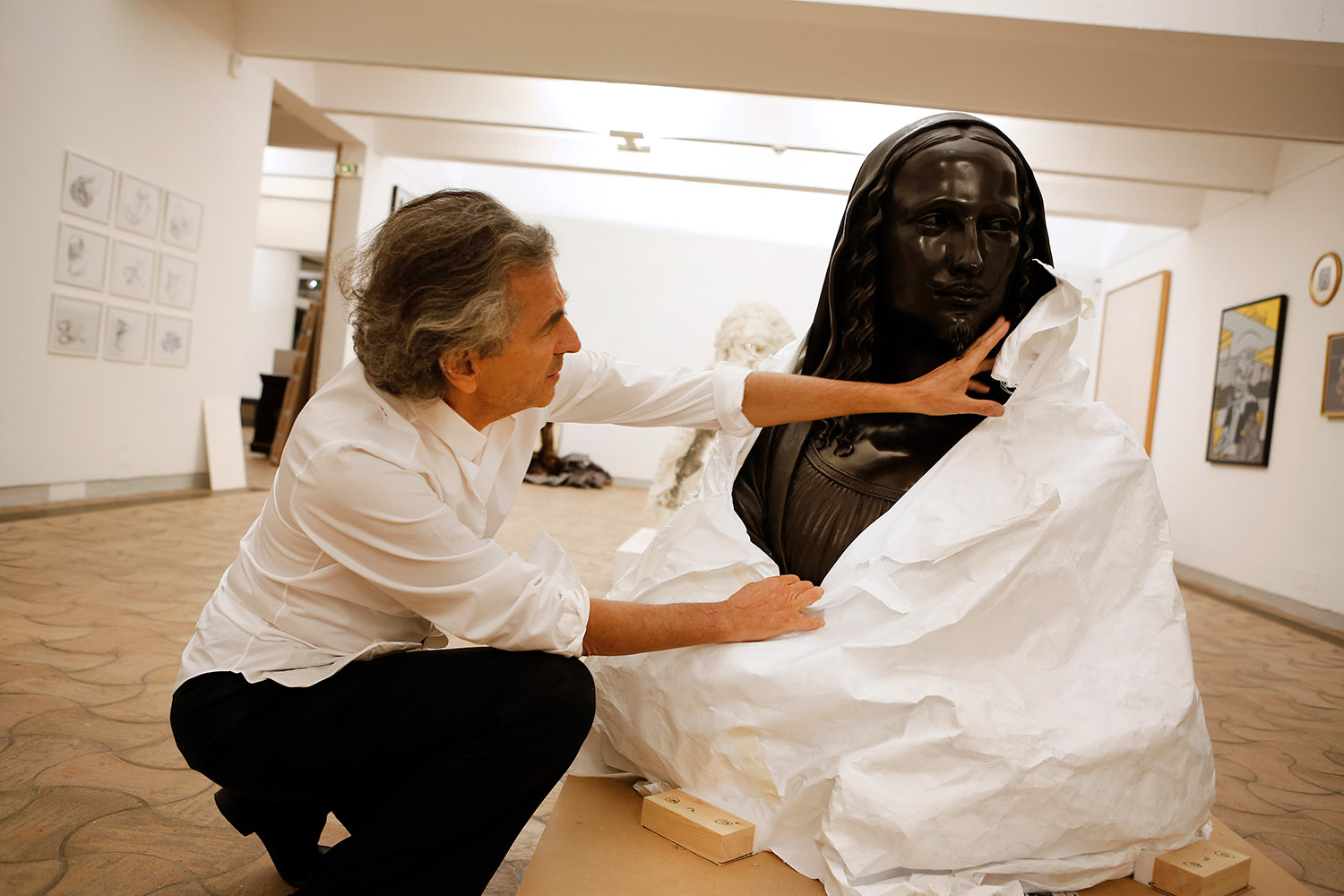 BHL déballe une sculpture, un buste, pour son exposition à la Fondation Maeght.