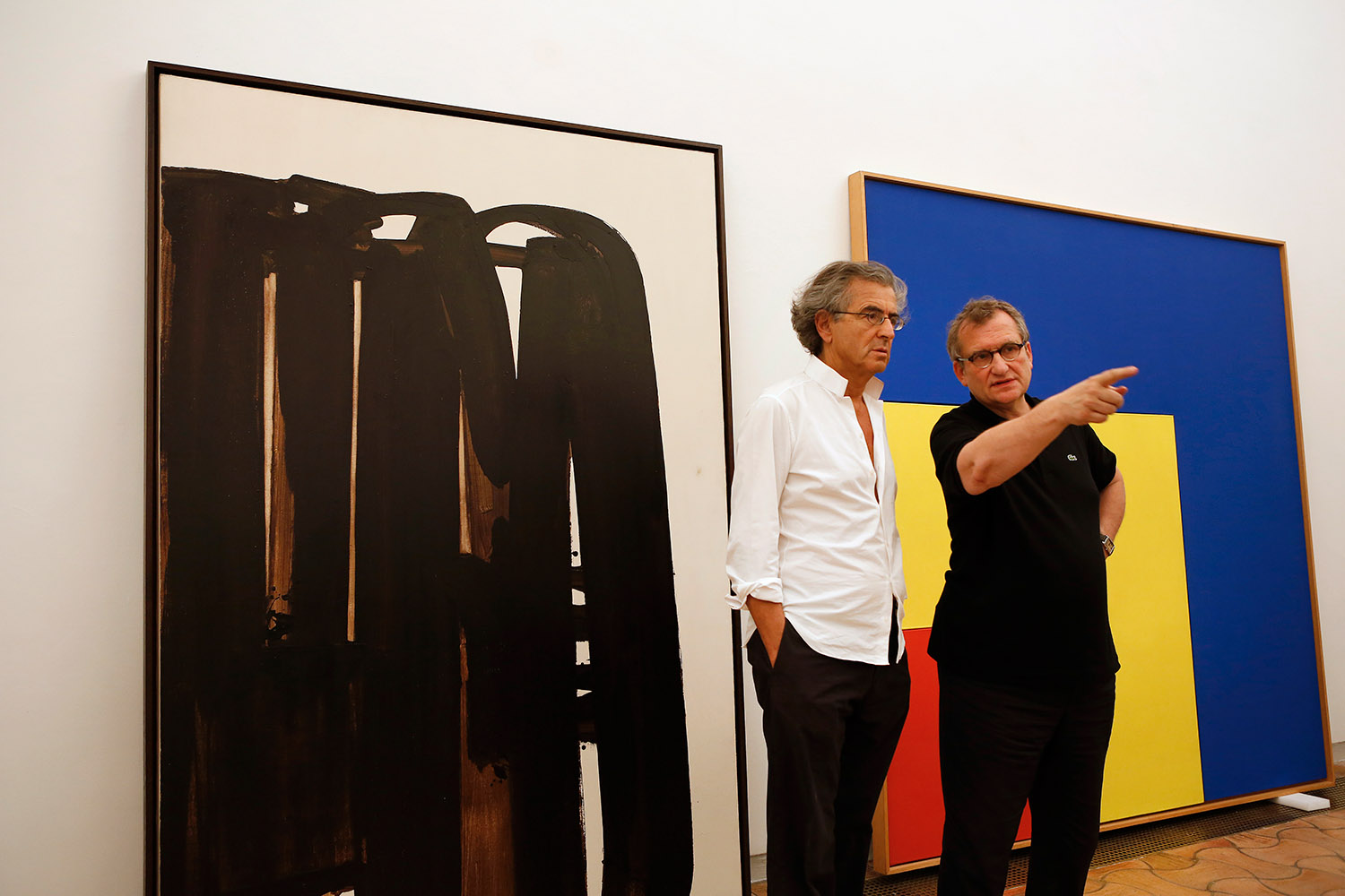 Olivier Kaeppelin et Bernard-Henri Lévy, à la Fondation Maeght. Ils parlent devant deux grands tableaux dont un de Soulage.