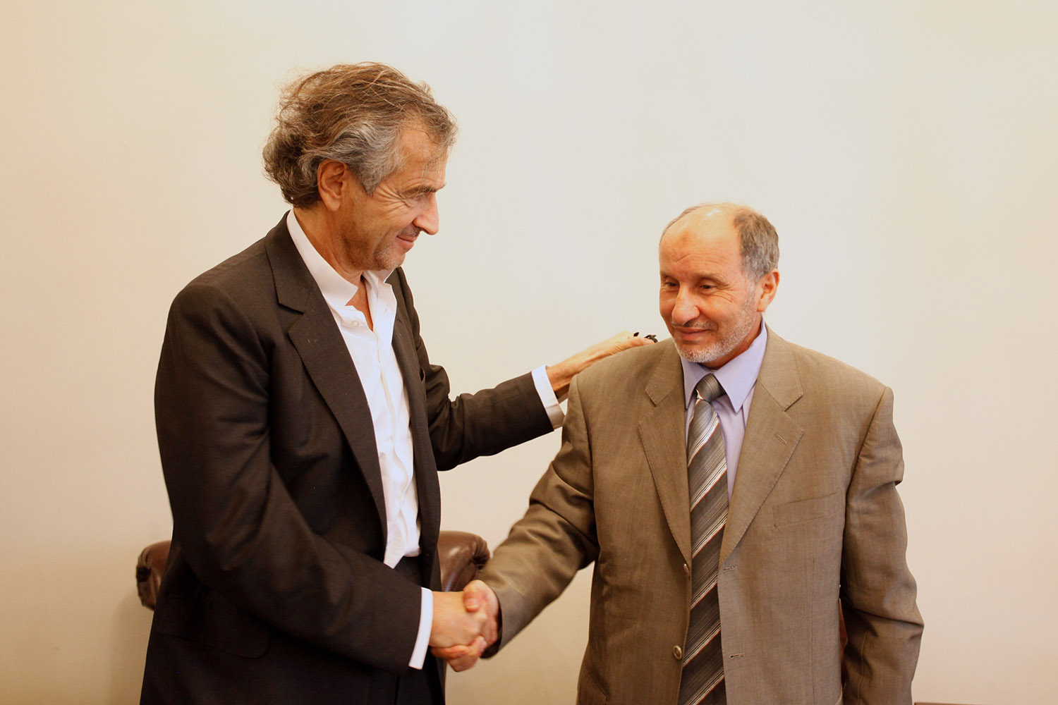 Bernard-Henri Lévy et le président du Conseil national de transition (CNT), Moustapha Abdeljalil, à Benghazi. Ils se sert la main.