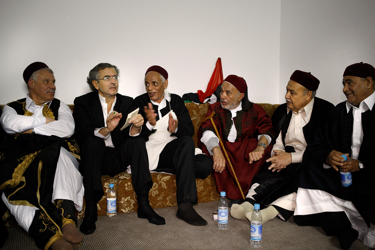 Bernard-Henri Lévy participe à la création du CNT, Conseil National de Transition en Libye. Il est sur un canapé entouré par des responsables libyens