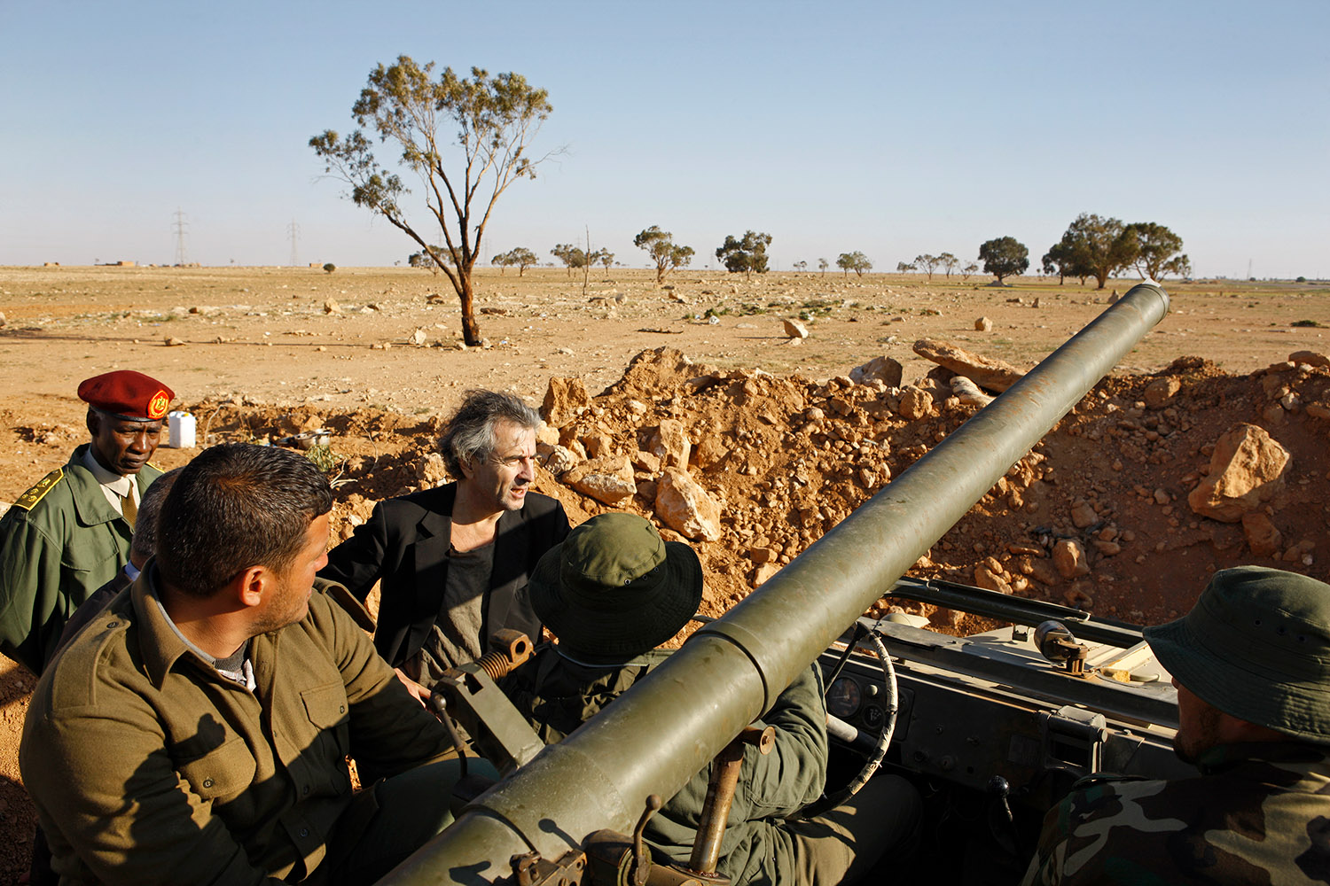 Bernard-Henri Lévy est sur le front, avec les rebelles Libyens à Ajdabiyah, en avril 2011. Il est a côté d'un élément d'artillerie avec des militaires.