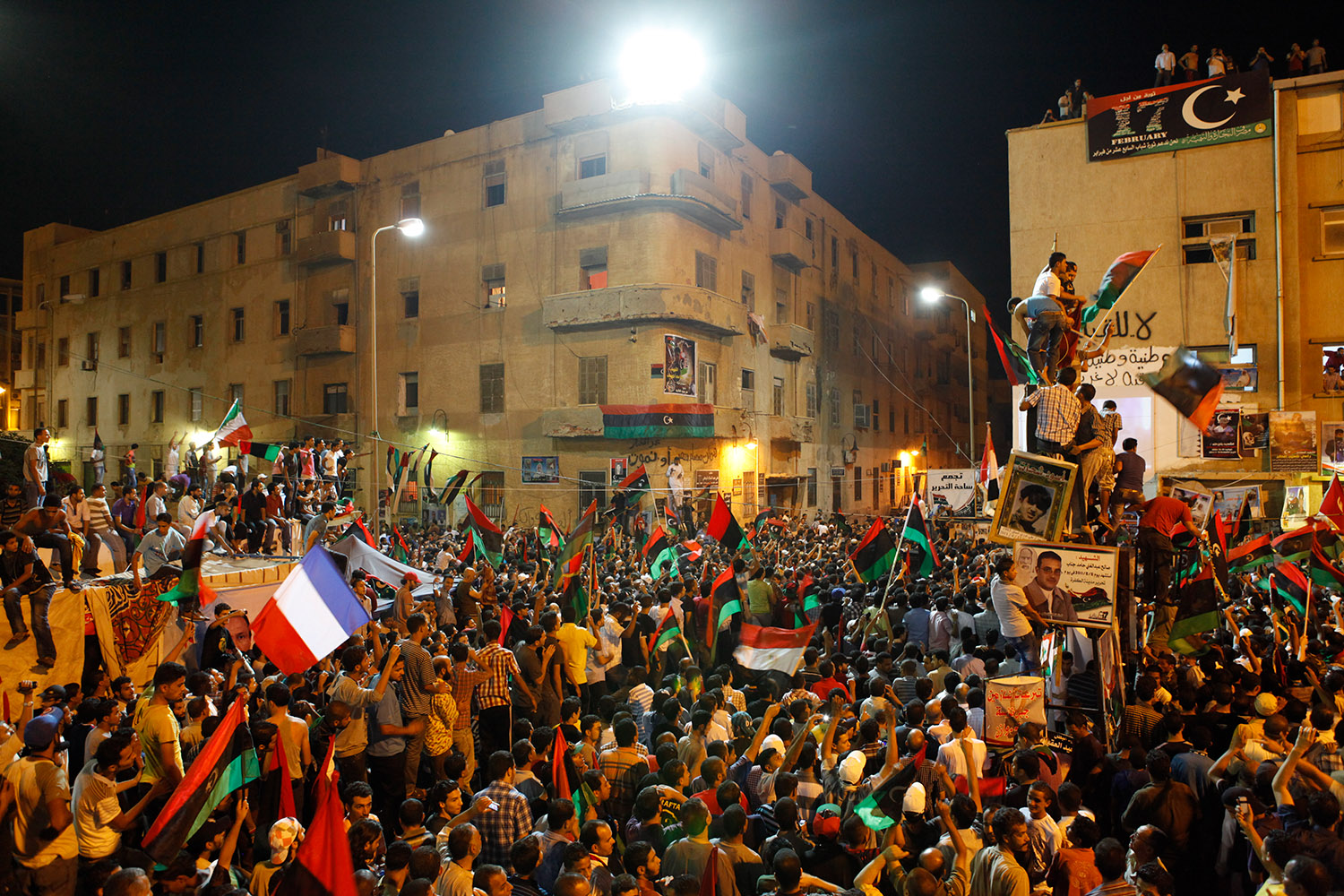 Les rebelles libyens à Benghazi en août 2011. La manifestation a lieu la nuit. On voit des drapeaux français parmi les drapeaux libyens.