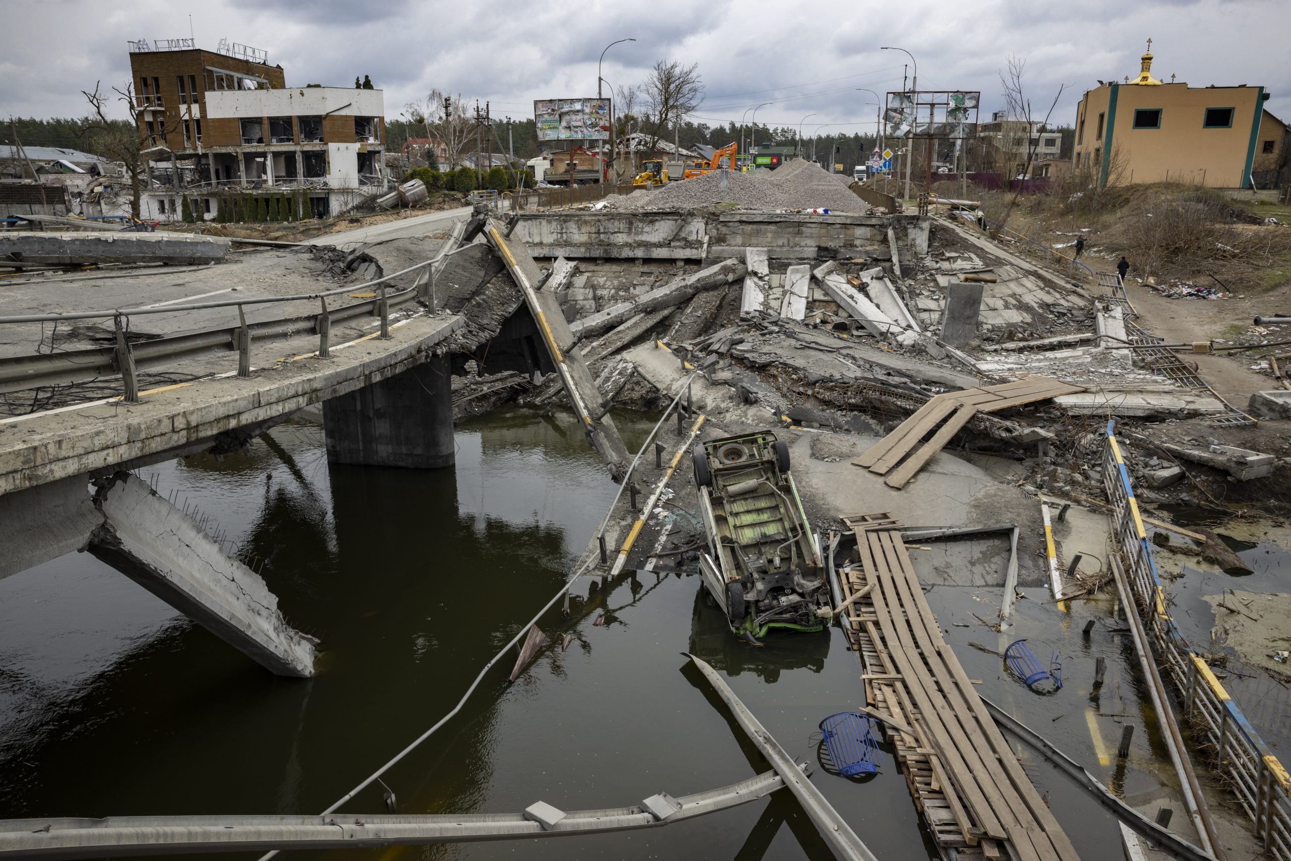 Le pont d'Irpin en Ukraine s'est effondré suite à une explosion. Au bord de l'eau, près d'une voiture retournée plongée dans l'eau