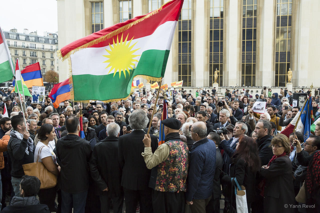 Bernard-Henri Lévy prononce un discours au Trocadéro à Paris, devant une foule, sous les drapeaux kurdes.