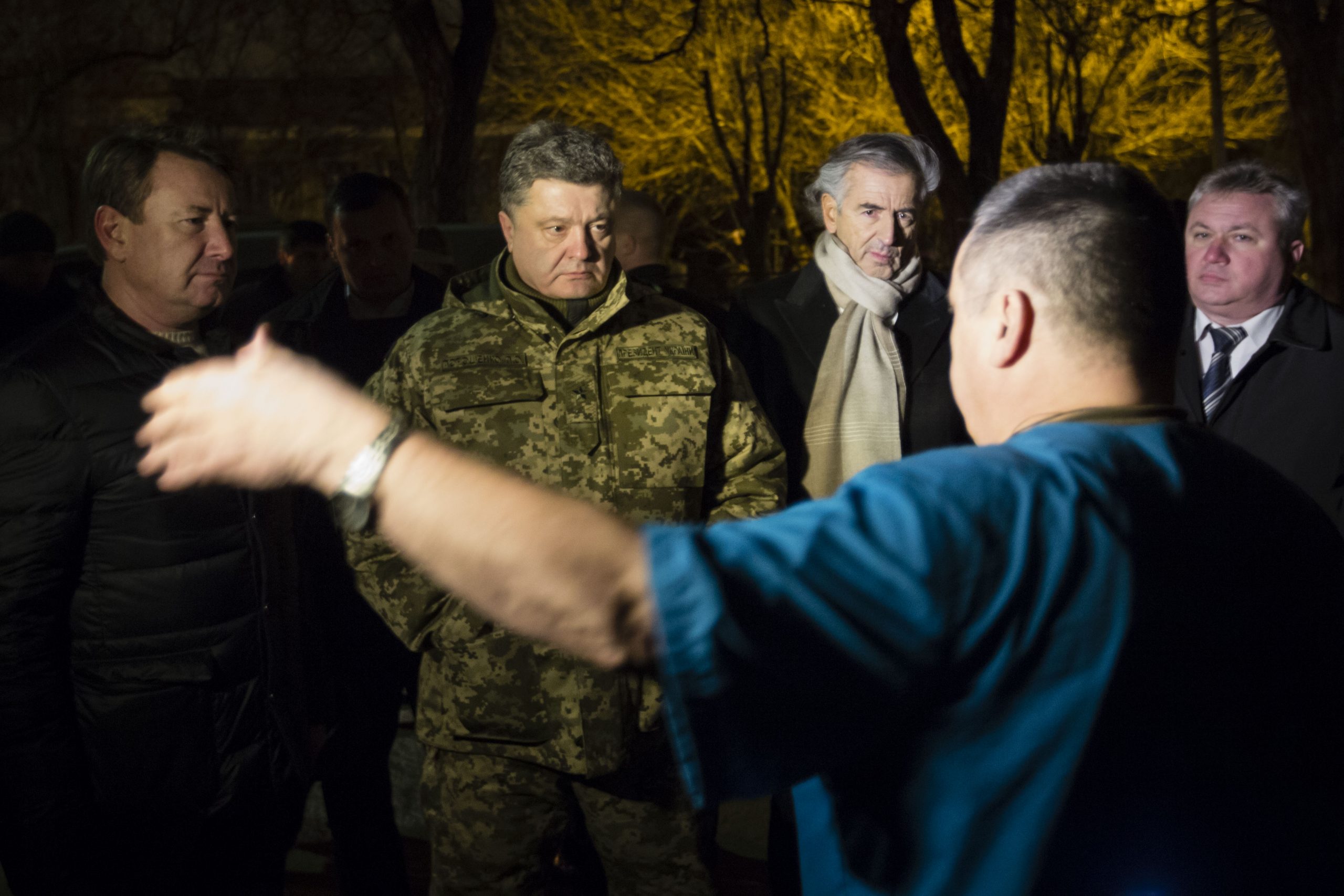 Bernard-Henri Lévy et Petro Porochenko, à Kramatorsk, la nuit, écoutent un homme qui parle.