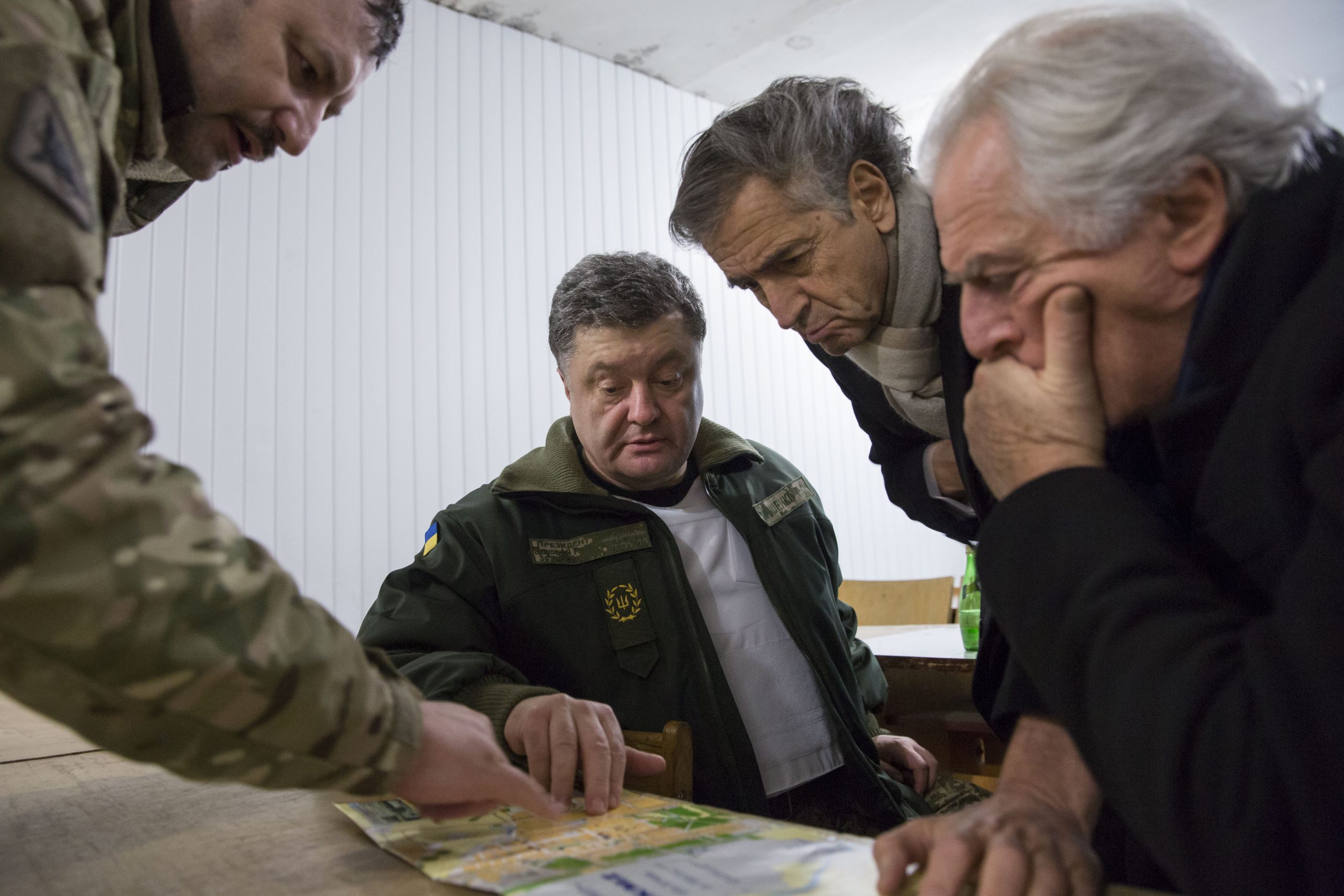 Bernard-Henri Lévy, Petro Porochenko et Gilles Hertzog, à Kramatorsk, se penchant sur une carte géographique.