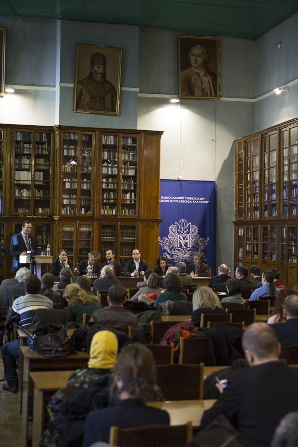 Présentation du Forum européen à l'Université de Kiev le 3 mars 2014. Une table avec des micros est installée devant une bibliothèque. Bernard-Henri Lévy est assis derrière cette table avec d'autres intellectuels.