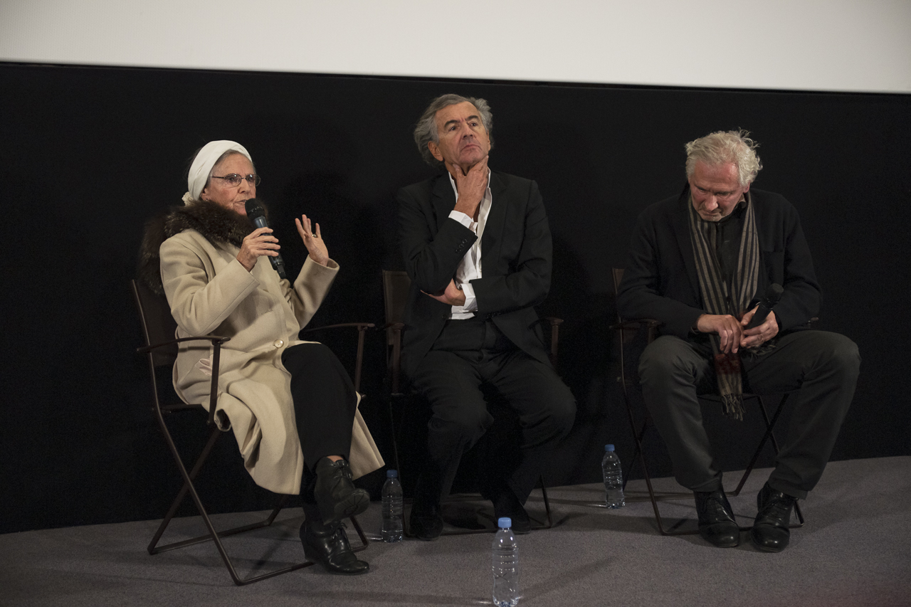 Catherine Robbe-Grillet, Bernard-Henri Lévy et Olivier Corpe, assis sous un écran de cinéma.