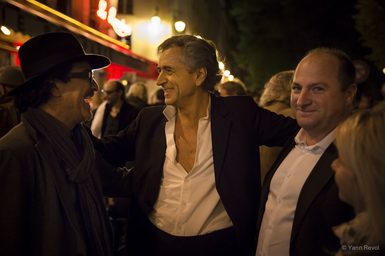 Atiq Rahimi et Bernard-Henri Lévy devant un cinéma la nuit.