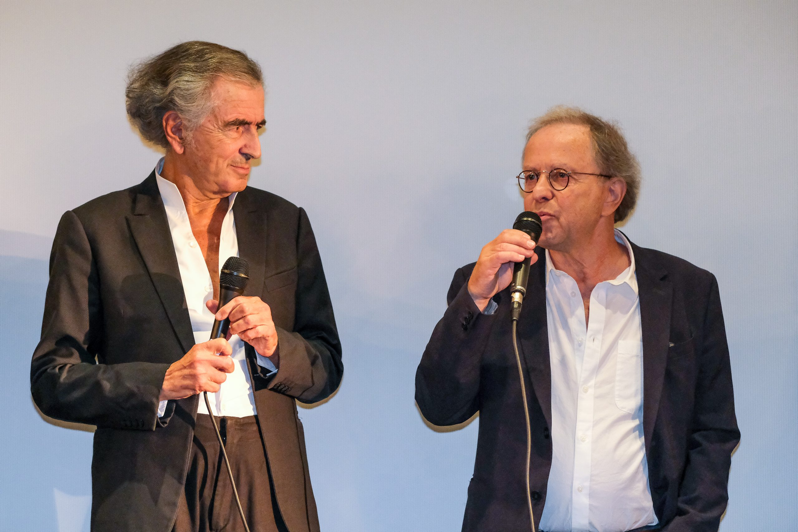 Bernard-Henri Lévy et François Margolin parlent devant un écran de cinéma