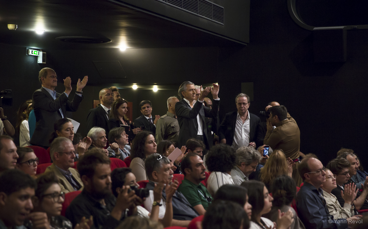 Bernard-Henri Lévy debout dans une salle cinéma remplie