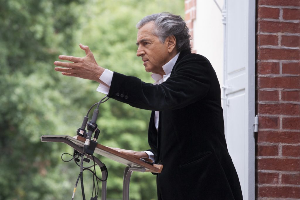 Bernard-Henri Lévy prononce un discours dans la maison de Zola, derrière un pupitre doté de micros il s'adresse au public.