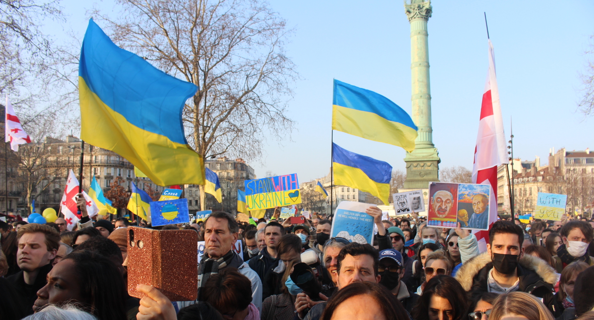 Place de la Bastille, les manifestants soutiennent l'Ukraine, avec des drapeaux et des pancartes aux couleurs de l'Ukraine, le jaune et le bleu. Au fond on voit la colonne de la Bastille.