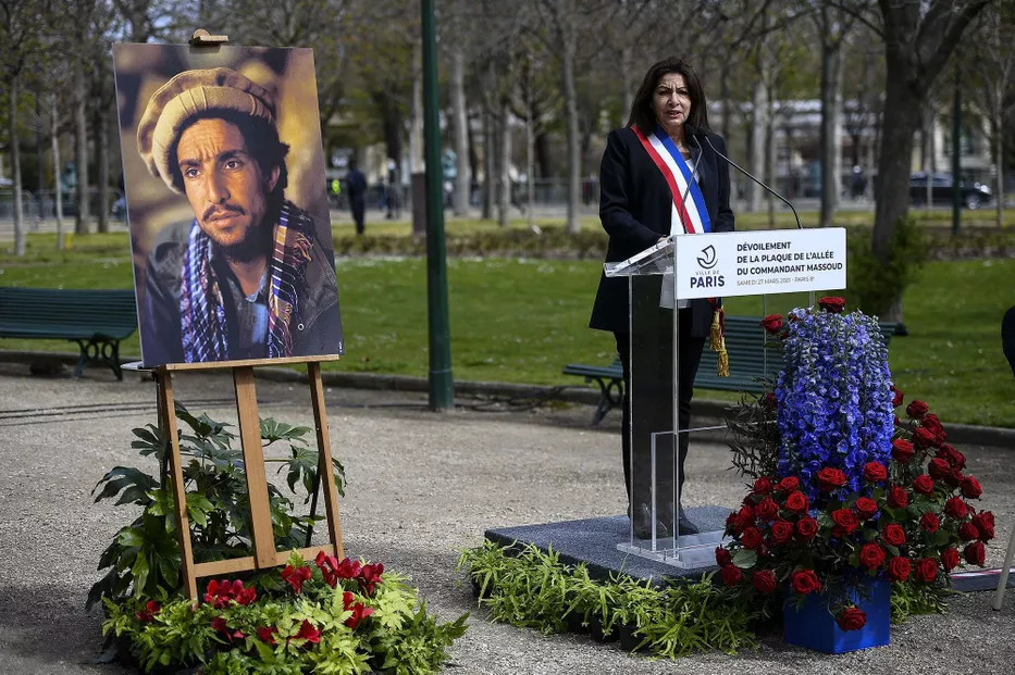Anne Hidalgo prononce un discours. À droite il y a un portrait du commandant Massoud et des gerbes de fleurs.