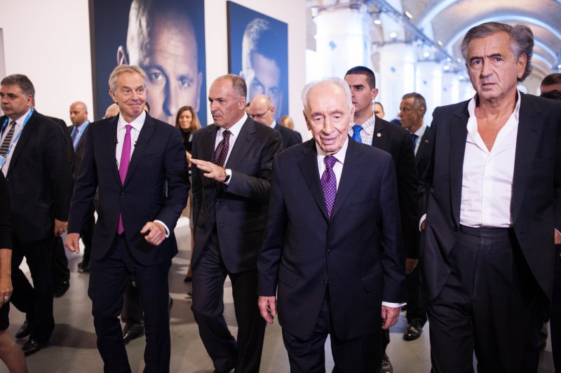 Bernard-Henri Lévy avec Tony Blair et Shimon Pérès au Yalta European Strategy, ils marchent entourés par des hommes en costumes et des journalistes.