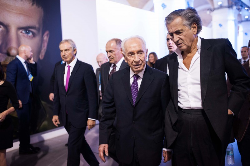 Bernard-Henri Lévy avec Tony Blair et Shimon Pérès au Yalta European Strategy, ils marchent entourés par des hommes en costumes et des journalistes.