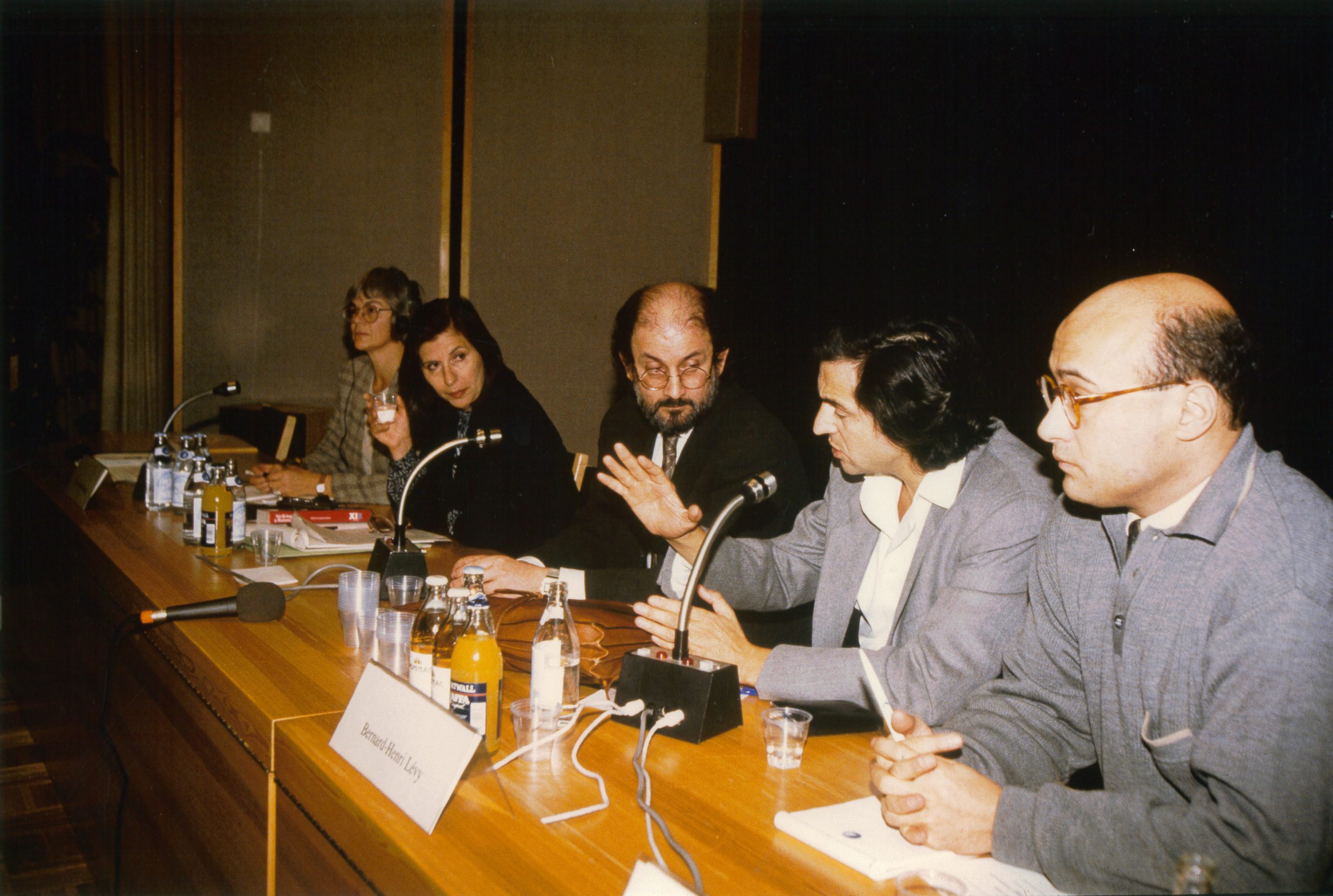 Bernard-Henri Lévy et Salman Rushdie assis derrière une table de conférence. Ils sont entourés, à la même table, par deux femmes et un homme.