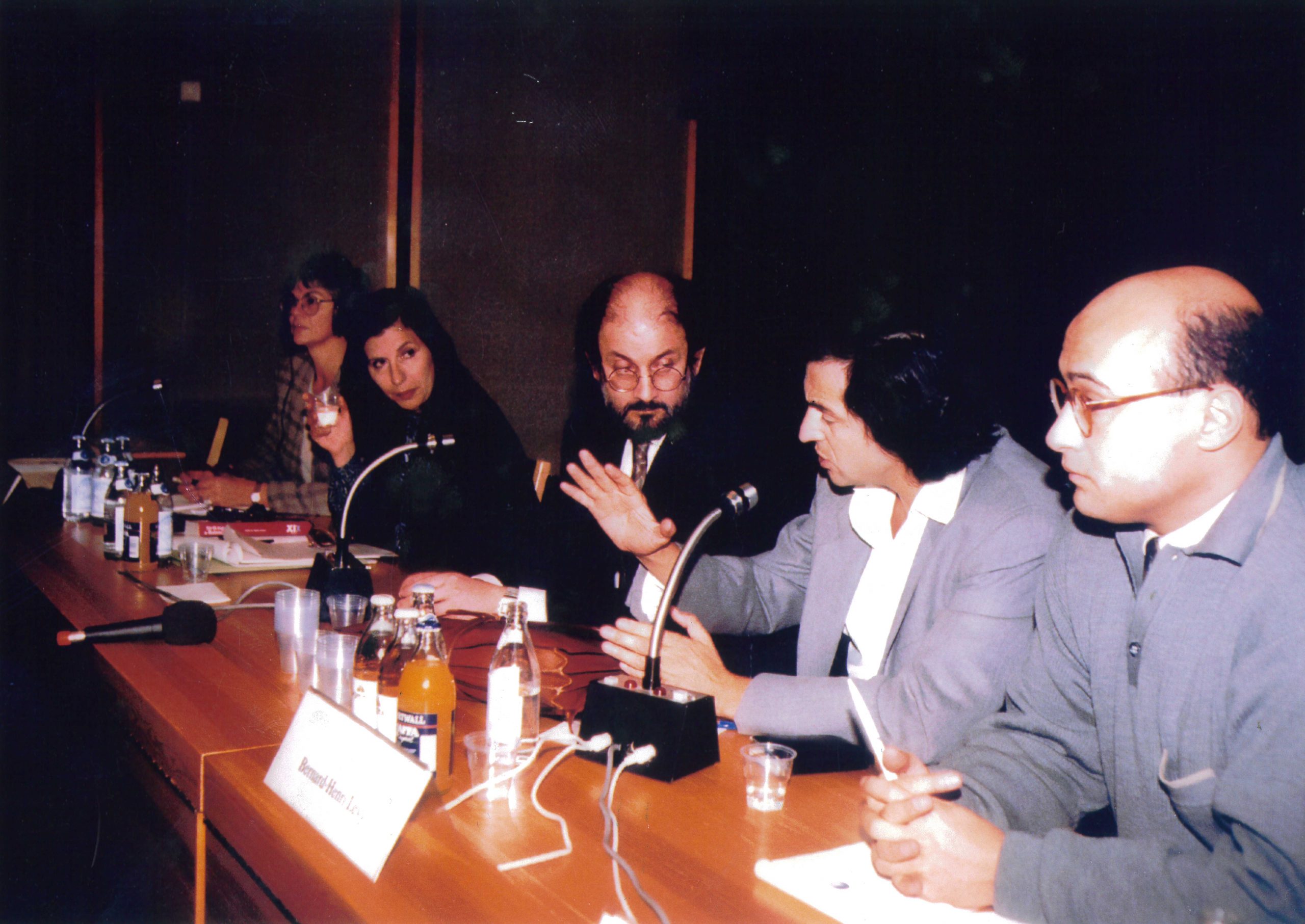 Gabi Gleichman, Bernard-Henri Lévy et Salman Rushdie à Helsinki, ils sont assis derrière une table sur laquelle sont posés des micros.