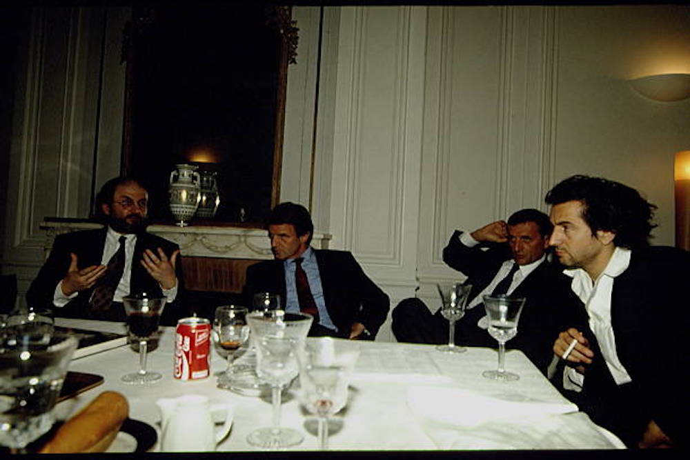 Salman Rushdie, Bernard Kouchner, François Léotard et Bernard-Henri Lévy parlent autour d'une table de dîner.